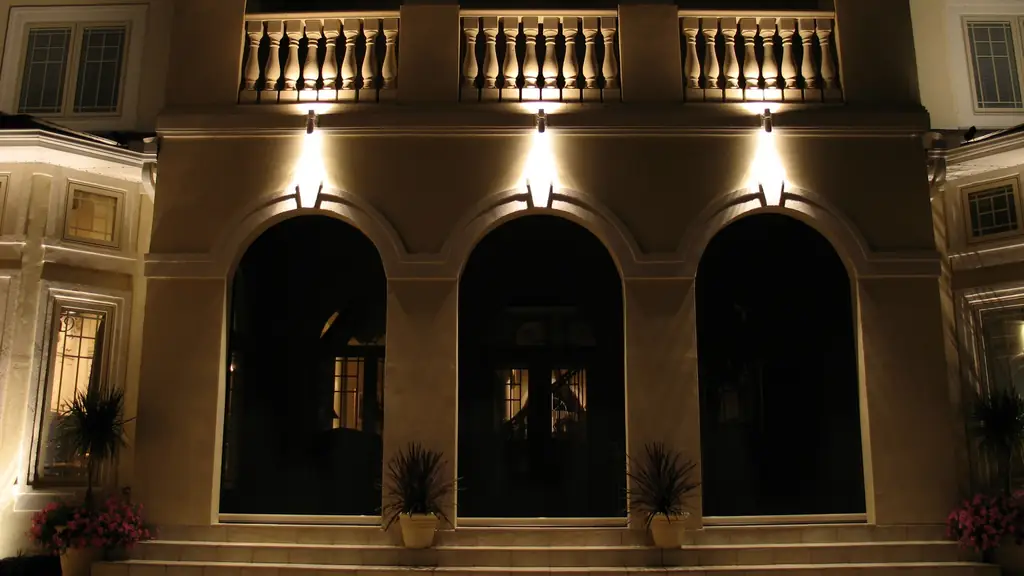 Stucco arcade at night with each arch lit by a concealed downlight above it