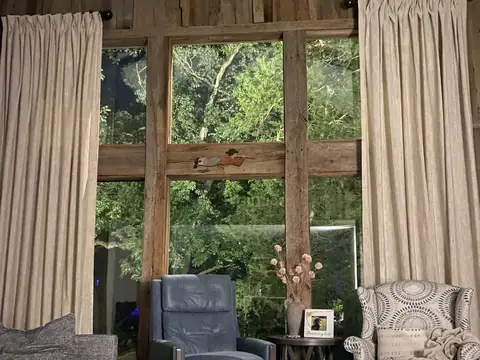 Living room with tall windows framing lit trees outside