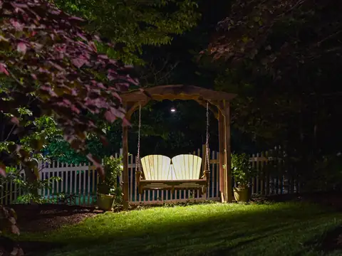 Arbor swing in a dark garden lit softly from above