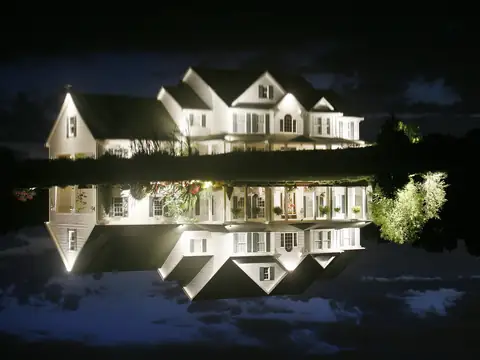 White house lit at night and mirrored in the still lake below it