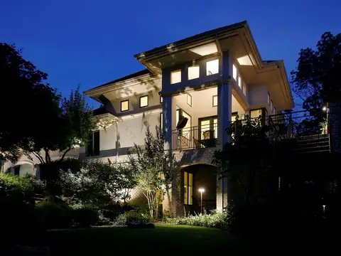 Modern multi-level home at dusk with layered landscape lighting