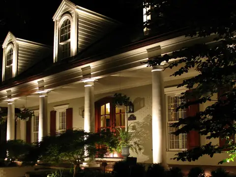 White columned porch with downlights recessed into the porch ceiling